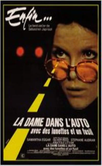 La dame dans l'auto avec des lunettes et un fusil